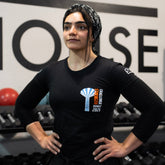 Person wearing a black t-shirt with a logo in a gym setting